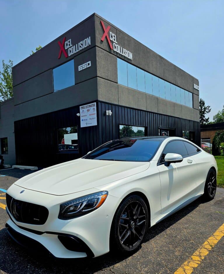 White luxury car outside collision center